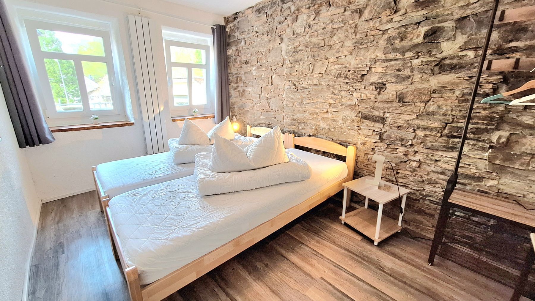Schlafzimmer Konrad mit einer alten freigelegten Bruchsteinmauer.